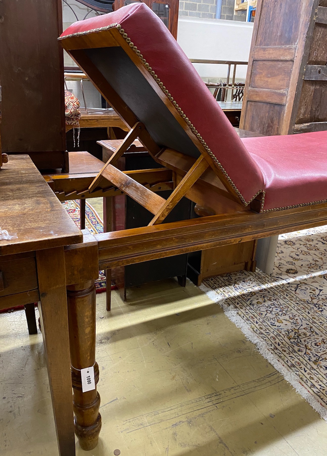 An Edwardian mahogany examination table by Ferris & Co. with red leatherette upholstery, length 186cm, height 63cm